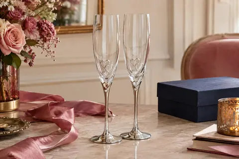 Deux flûtes à champagne en verre avec motifs de cœur, strass et bases en métal argenté